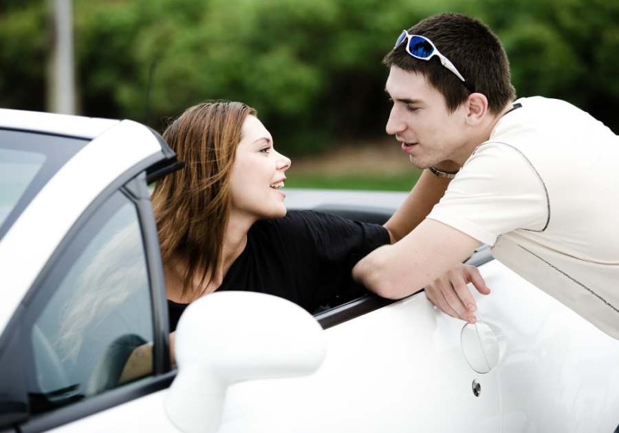 man leaning into woman's car Do Guys Like Being Called Handsome