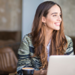 woman sitting in office at desk smiling Tinder Bios for Women