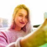 woman smiling looking at phone Snapchat Cheating