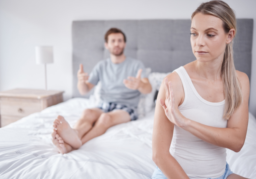 woman sitting on end of bed man on other end of bed Signs Your Wife Is Not Sexually Attracted to You