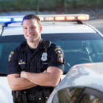 law enforcement officer smiling beside car dating a cop