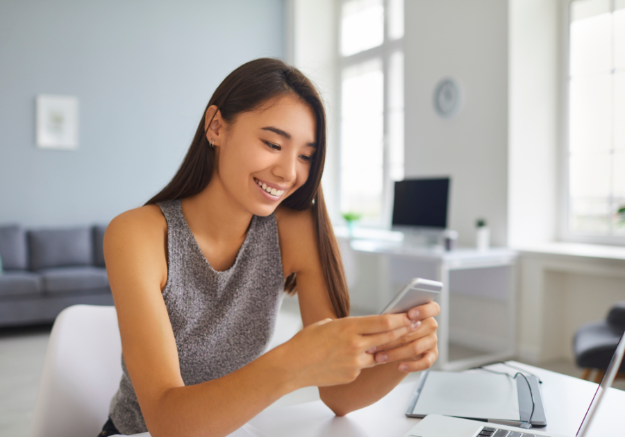 woman looking at phone smiling Tinder Bios for Women