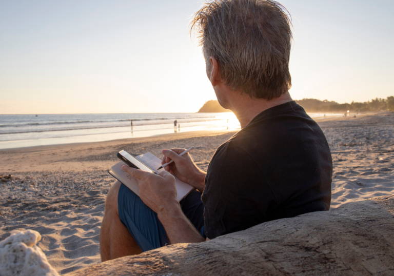man writing in journal on beach Missing You Poems