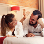 couple laying on bed talking Fun Questions to Ask Your Boyfriend 