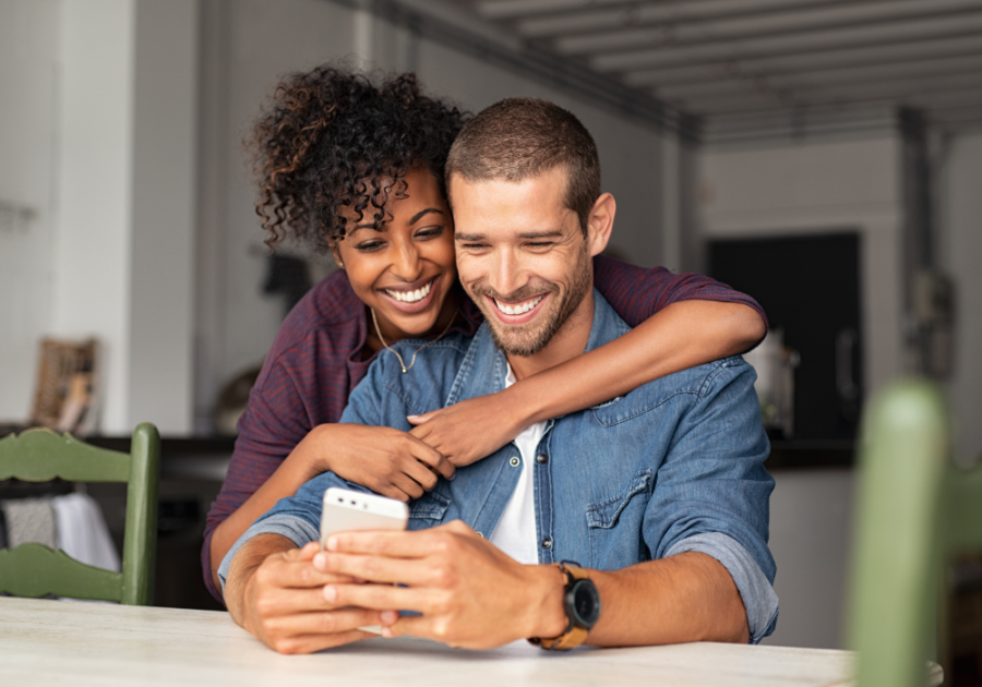 woman hugging man from behind looking at phone Best Favorite Things Questions