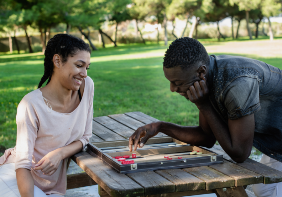 couple outdoors playing backgammon  on picnic table games to play with your girlfriend