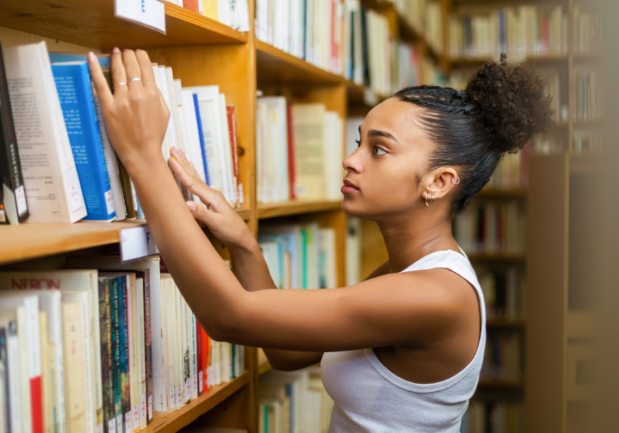 woman looking at books on shelf Smartest Zodiac Sign