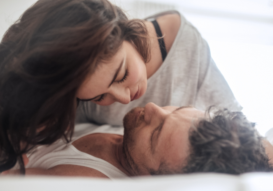 woman kissing man laying on his back Juicy Questions to Ask Your Girlfriend