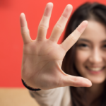 woman smiling holding up her hand Put a Finger Down Questions