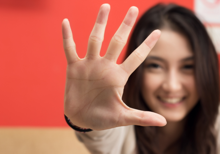 woman smiling holding up her hand Put a Finger Down Questions