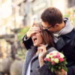 woman laughing at man covering her eyes Make Your Girlfriend Happy
