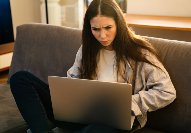 woman on sofa looking on laptop Why Did My Ex Block Me