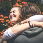 woman hugging man outdoors Why Do Girls Hug Guys Around the Neck