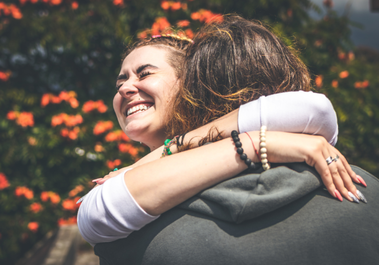 woman hugging man outdoors Why Do Girls Hug Guys Around the Neck