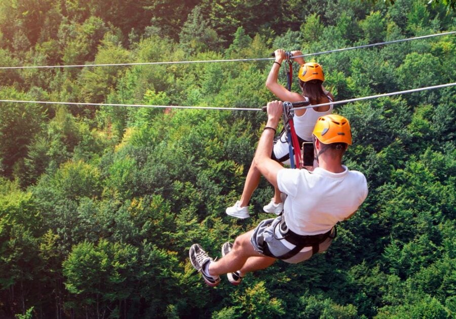 couple riding zip line outdoors Signs a Sagittarius Man Has Feelings for You