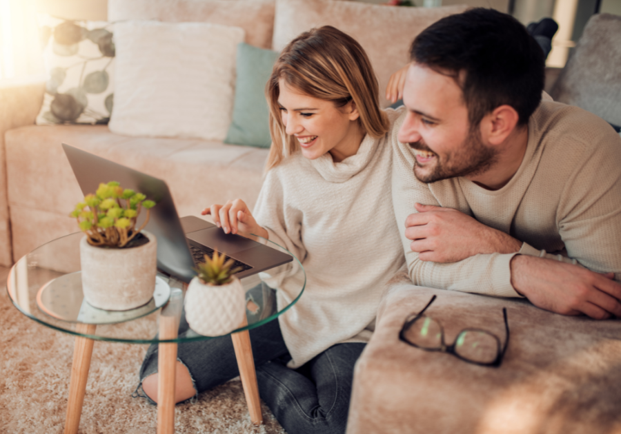 couple indoors looking at computer Would You Rather Questions for Couples