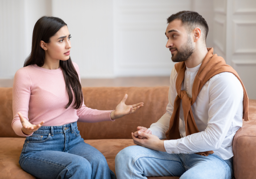 couple sitting on sofa and talking Does Body Count Matter