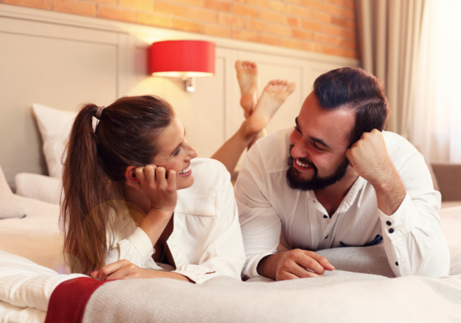 couple laying on bed talking Juicy Questions to Ask Your Boyfriend