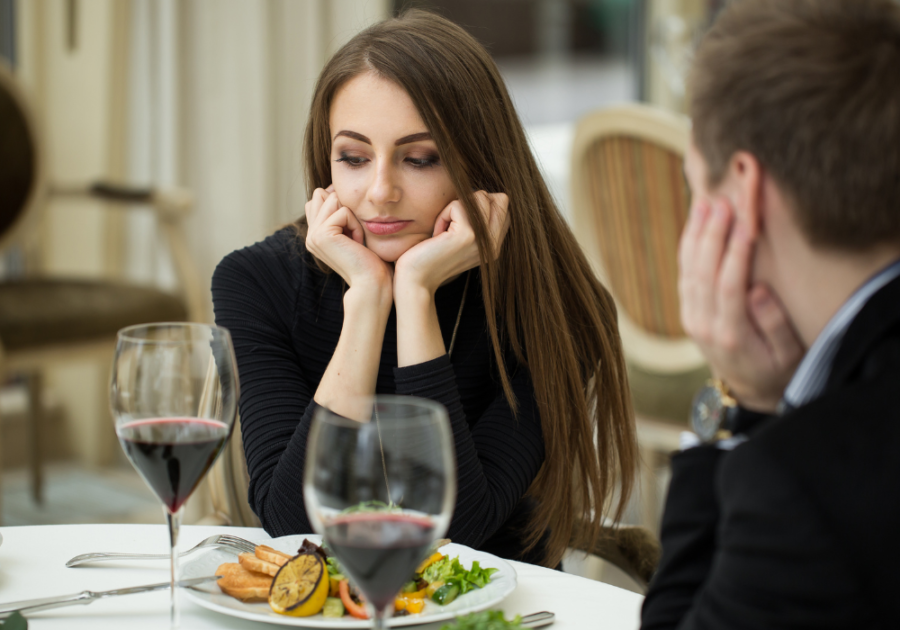 woman sitting at table Signs You Will Never Find Love