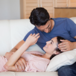 woman laying on man's lap on sofa Juicy Questions to Ask Your Girlfriend