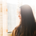 woman standing alone indoors signs you're healing from a breakup