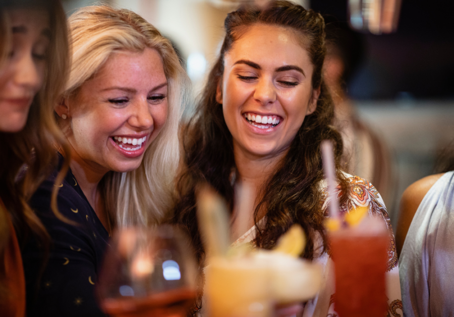 women laughing at restaurant table girls night questions