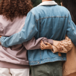 two women arms around man Symptoms of Bisexuality in Females