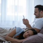 couple in bed man is looking at phone is secting cheating