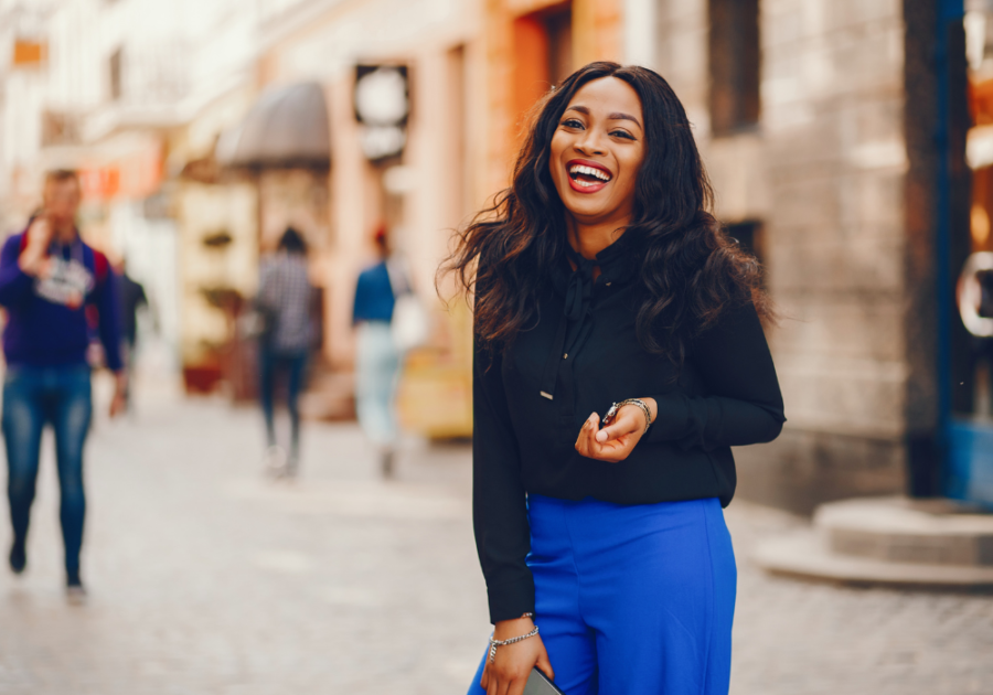 woman standing outdoors laughing Prettiest Zodiac Sign