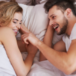 couple laying together in bed laughing NSA Relationship