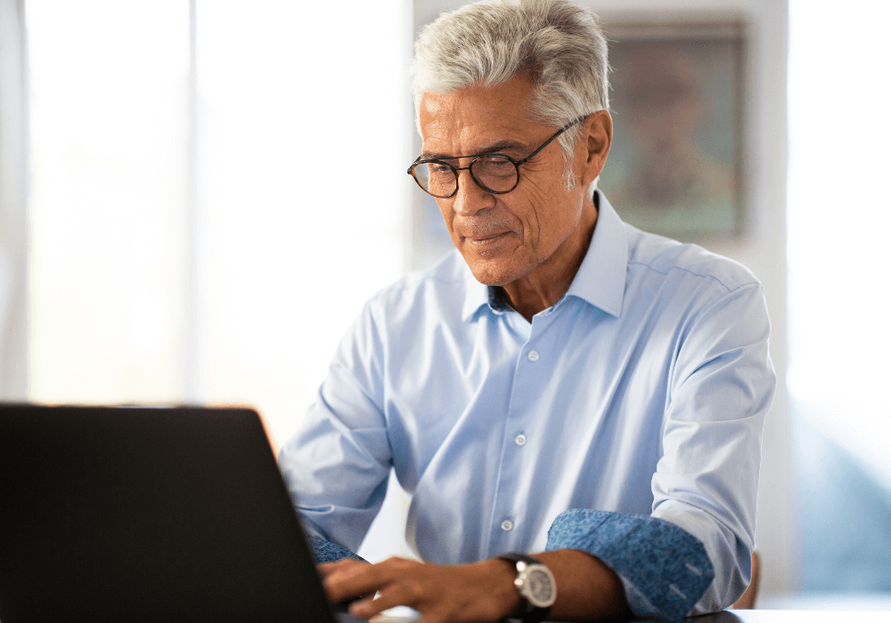 senior man writing email how to announce retirement
