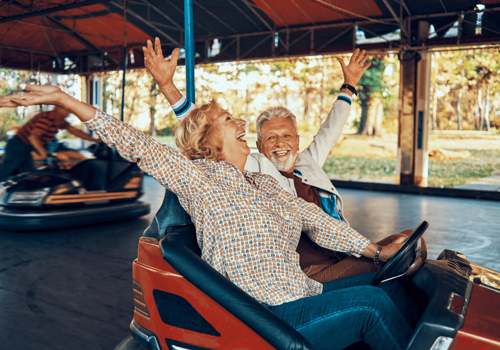 sweet senior couple enjoying bump cars retirement bucket list ideas