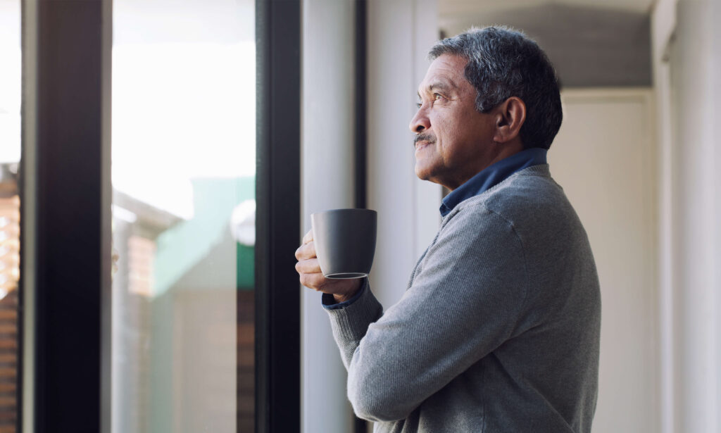 senior man drinking coffee looking in the window emotional signs you need to retire