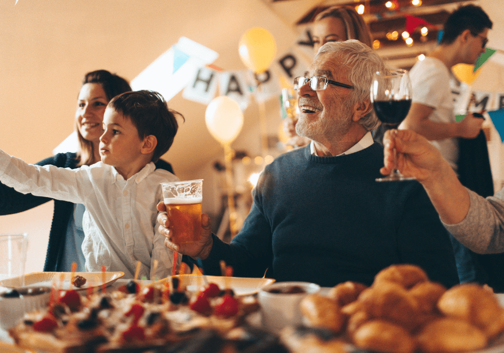 senior man holding a glass of beer at party best songs for retirement