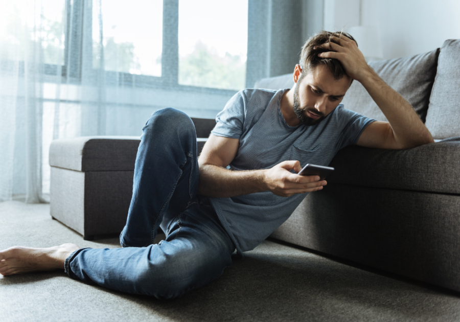 man sitting of floor looking at phone can a man sleep with a woman without developing feeling
