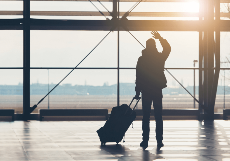 man with baggage waving his hands walking away from elderly parent