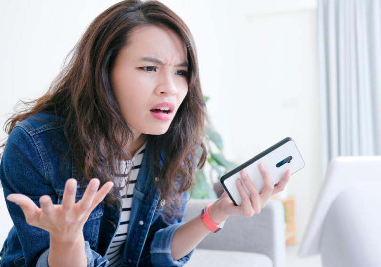 woman holding phone looking stressed signs of an immature woman