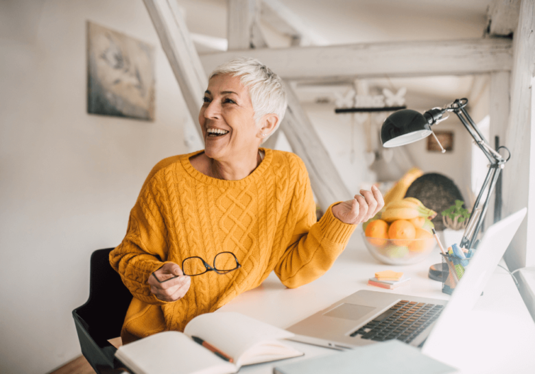 woman smiling while holding eyeglasses hobbies for women over 50