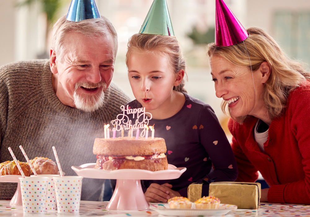 older couple sitting with child with birthday cake Birthday Wishes for Your Granddaughter