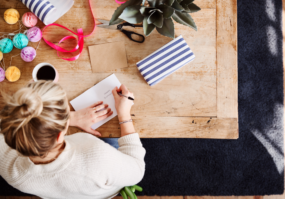 women writing card at table Birthday Wishes for Your Granddaughter